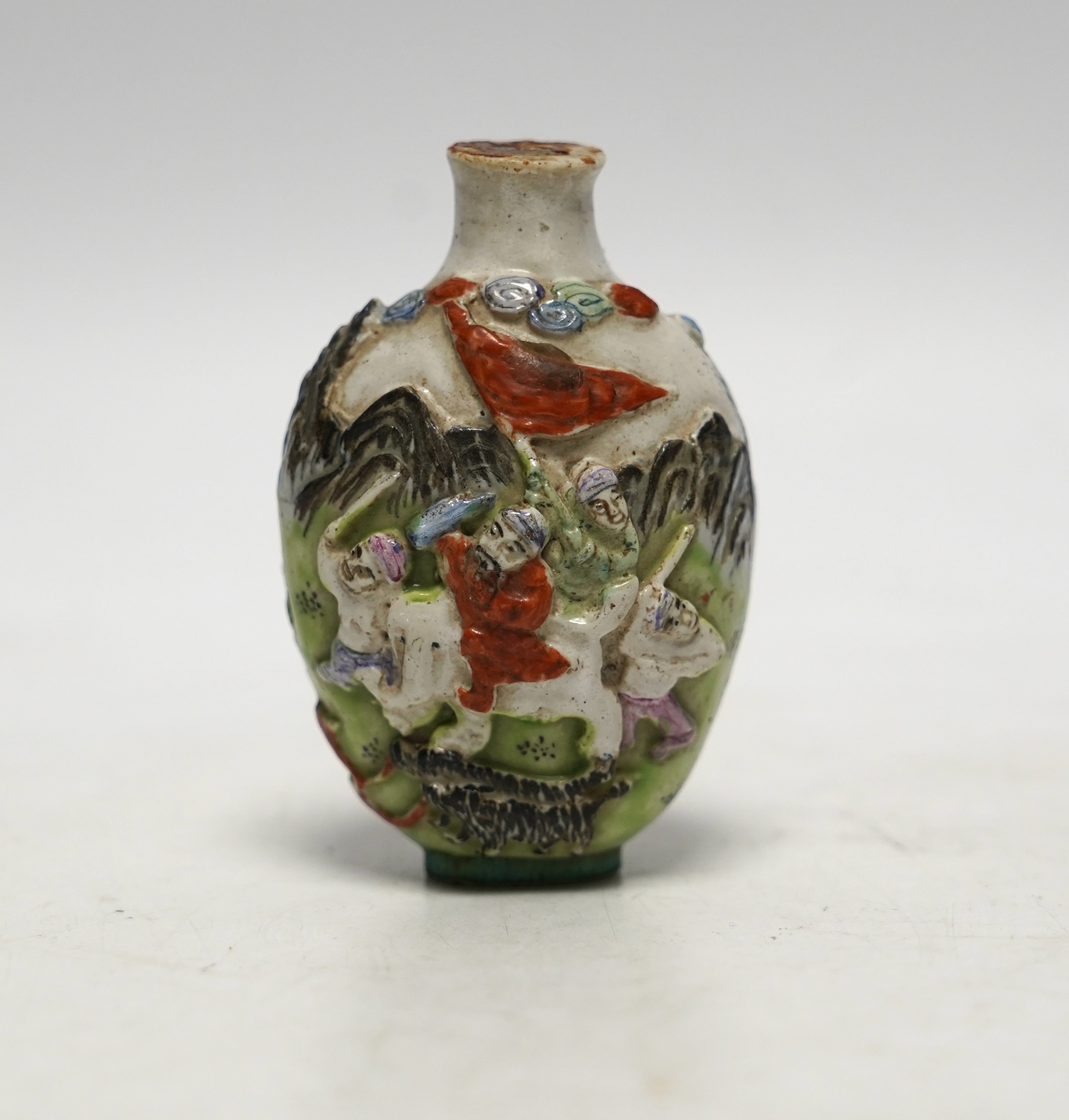 A Chinese moulded in enamelled porcelain ‘figures riding mythical beasts’ snuff bottle, Qianlong mark, 19th century, 8.5cm high
